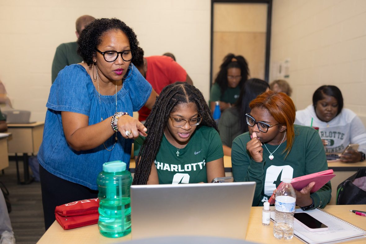 Person in a “Niners” jacket talking with others in a lounge.